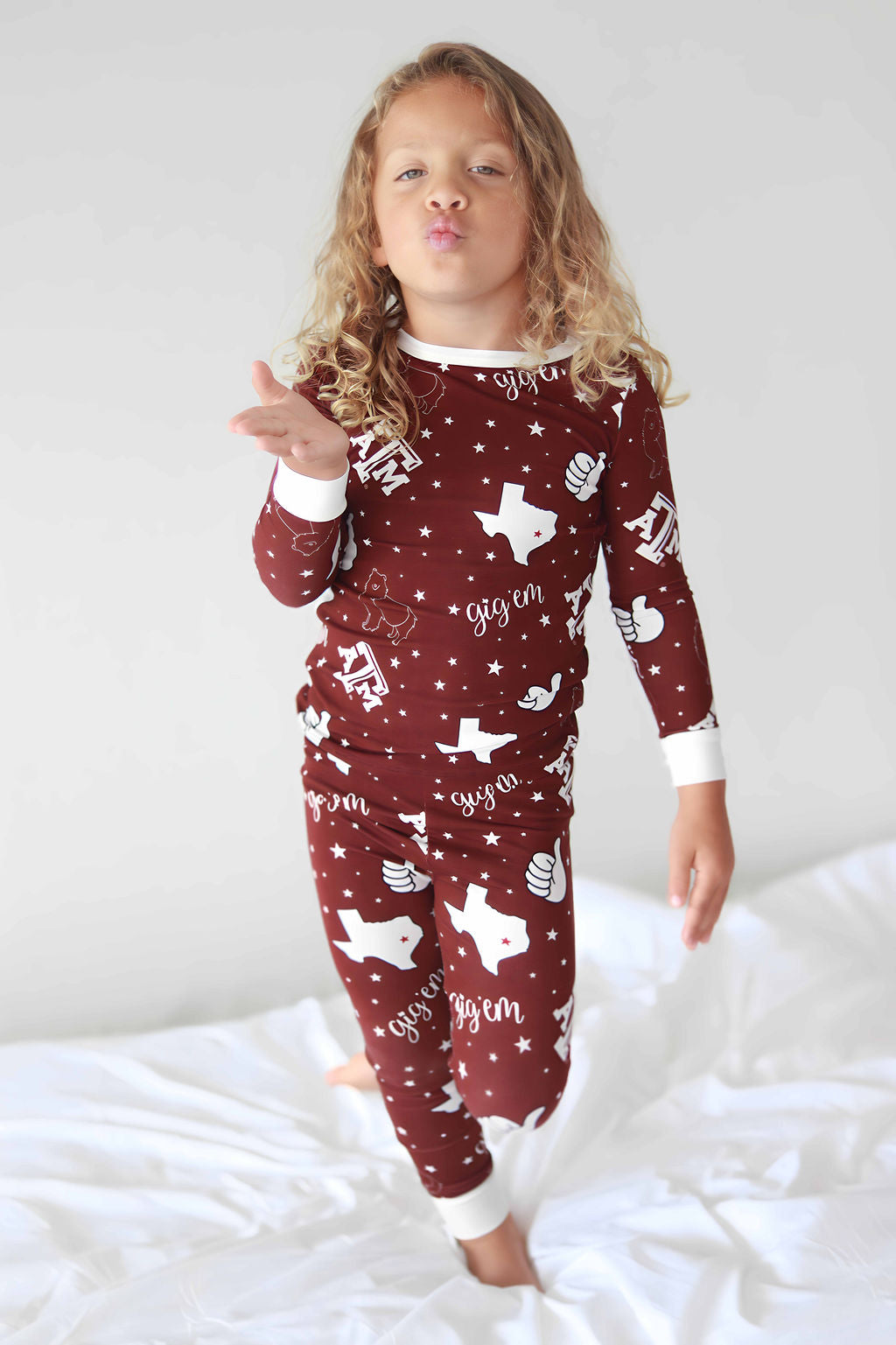 Toddler blowing a kiss in Texas A&M two piece bamboo pajamas