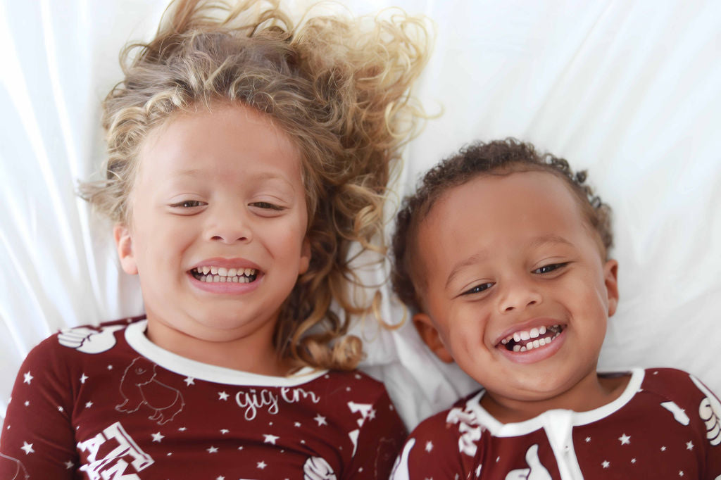 Ellie and Joey laying down laughing in Texas A&M print