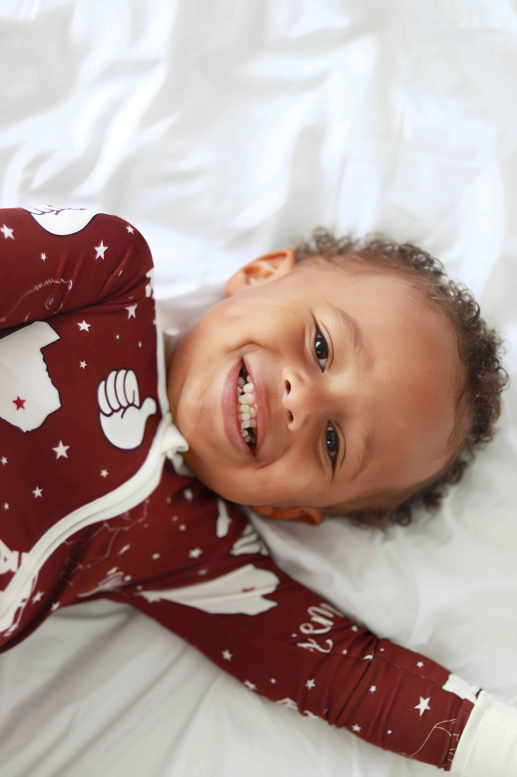 Baby smiling on back wearing Texas A&M Zippie