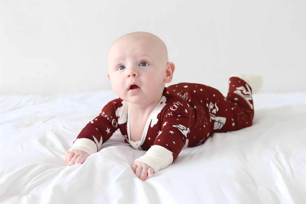 Baby with curious look on face wearing Texas A&M print