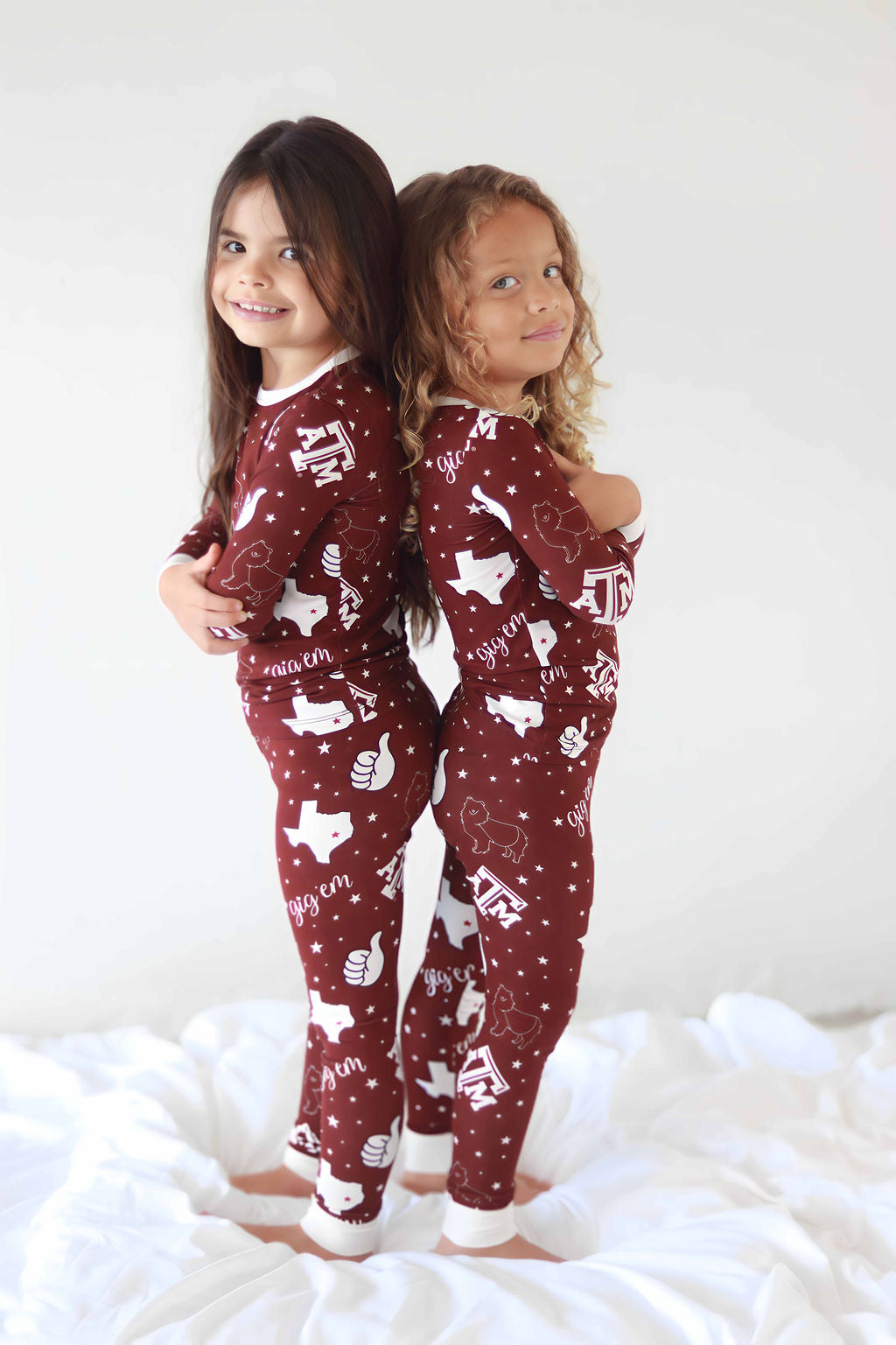 Two toddlers standing back to back in Texas A&M Print Two Piece Pajamas