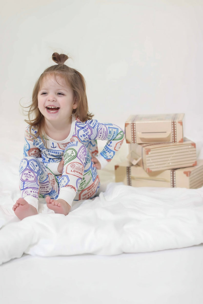 Laughing toddler in passport stamp pajamas